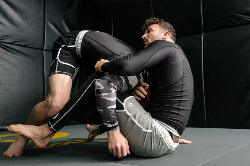 Två utövare tränar brasiliansk jiujitsu på mattan